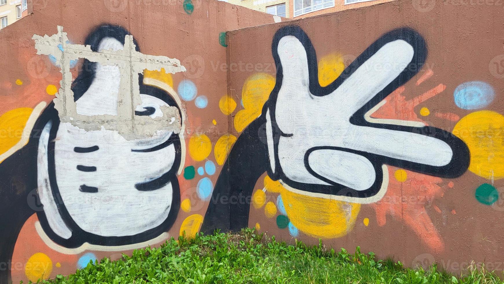 Aan de straat, gekleurde graffiti is geschilderd Aan de bruin muur van de huis foto