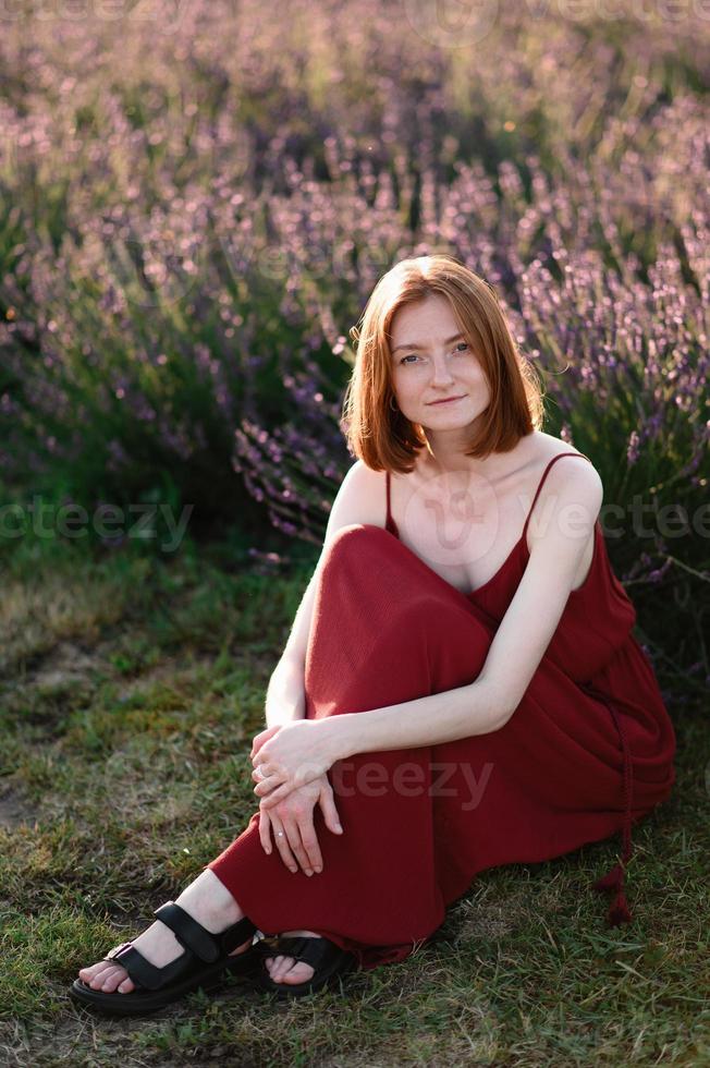 een roodharig jong meisje zonder bedenken is resting in een lavendel veld. zomer vakantie en reizen tijd. foto