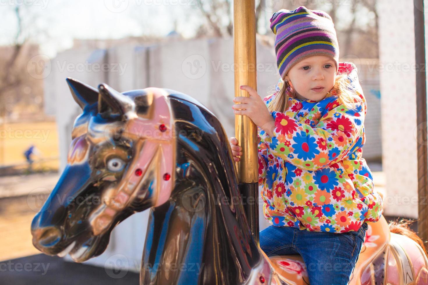 weinig meisje Aan een carrousel foto