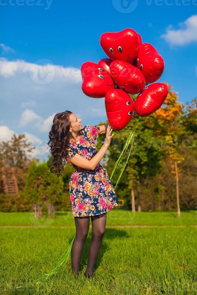 jong vrouw met rood hart ballonnen foto