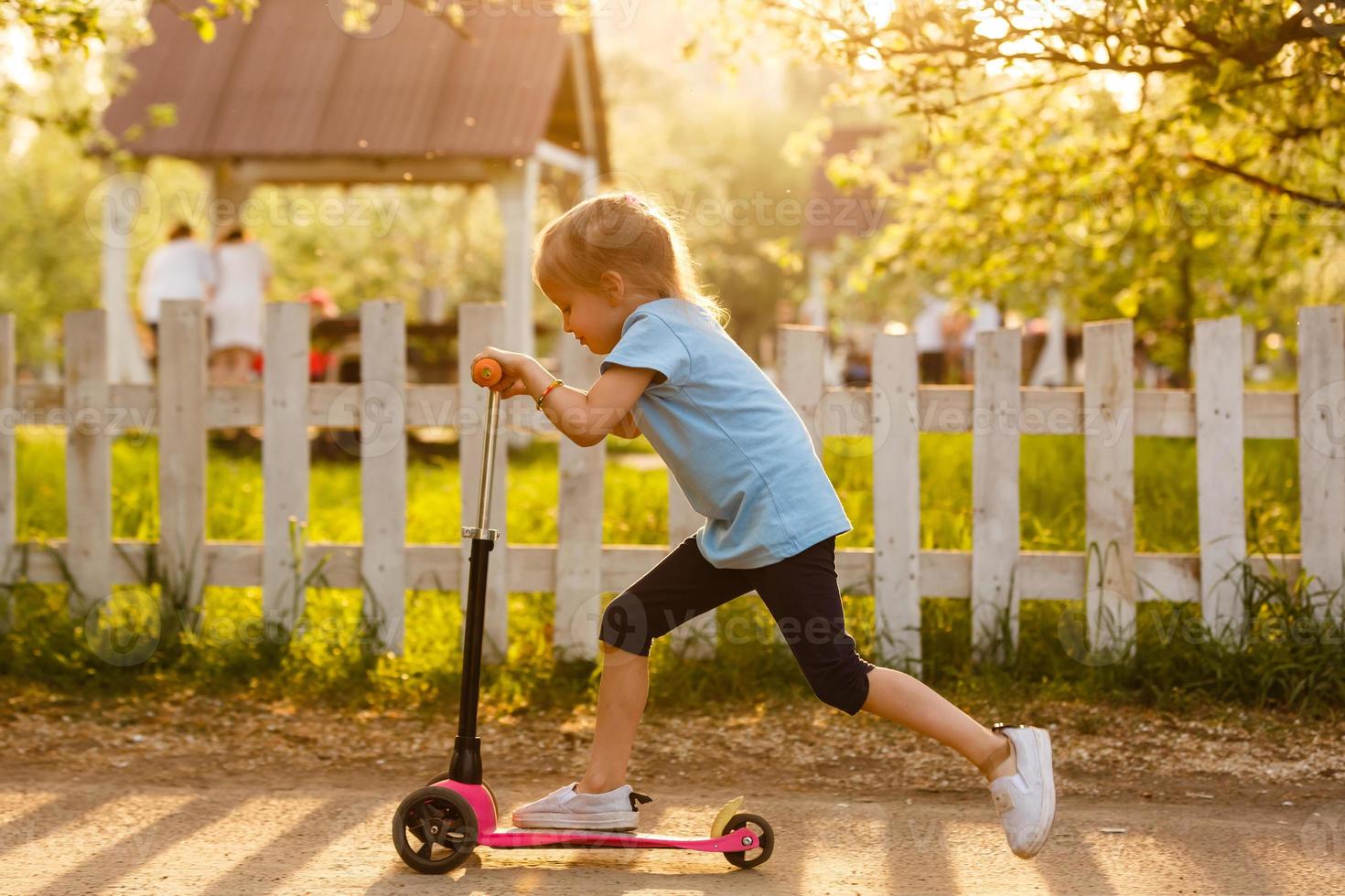 mooi meisje het rijden scooter Aan landelijk weg buitenshuis in natuur foto