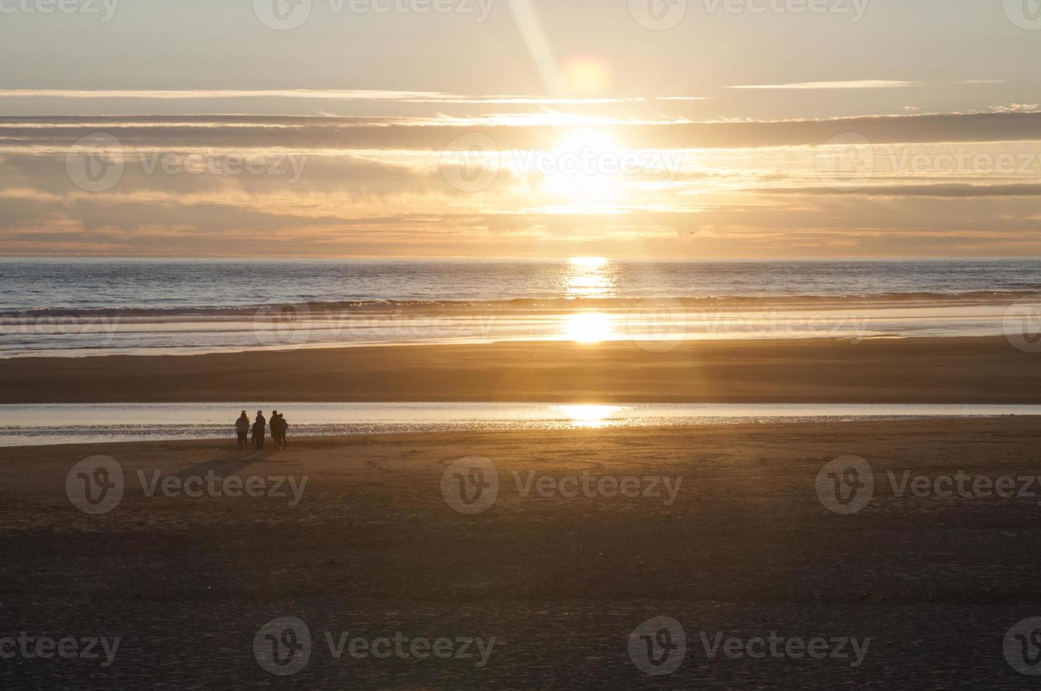 strand in oranje zonneschijn Bij zonsondergang foto