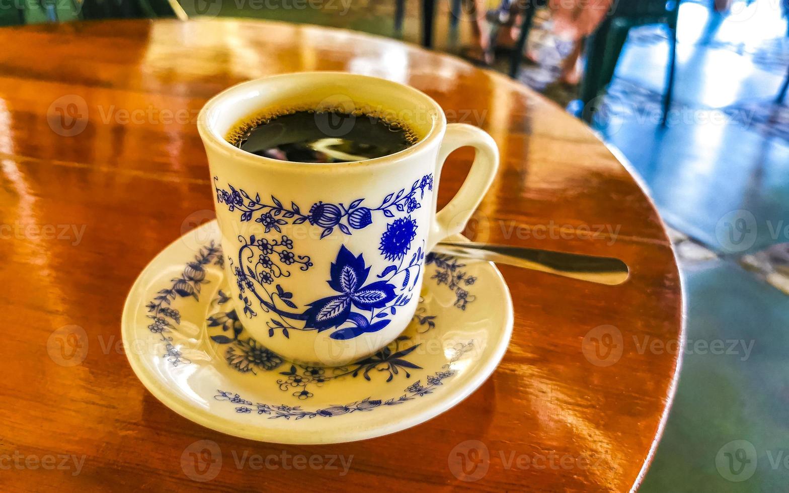 blauw wit kop pot met zwart koffie houten tafel Mexico. foto