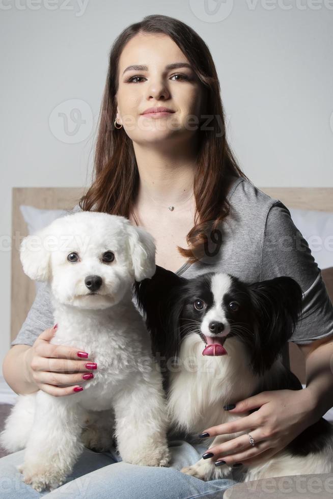 gelukkig meisje Holding schattig bichon en papillon honden. foto