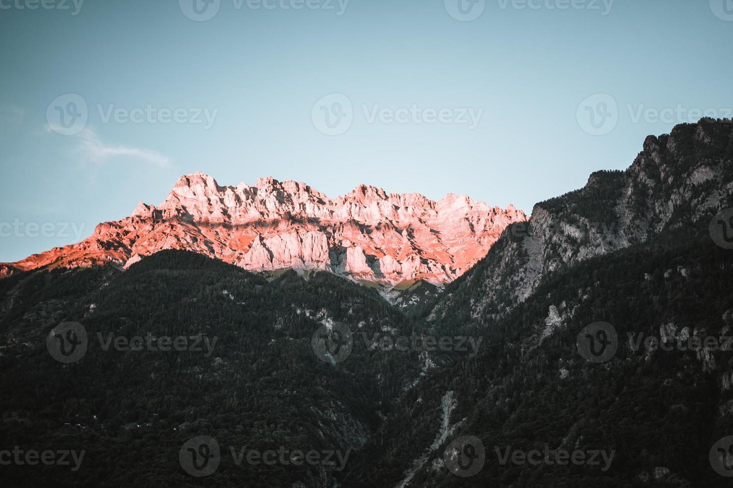 majestueus bergen in de Alpen gedekt met bomen en wolken foto