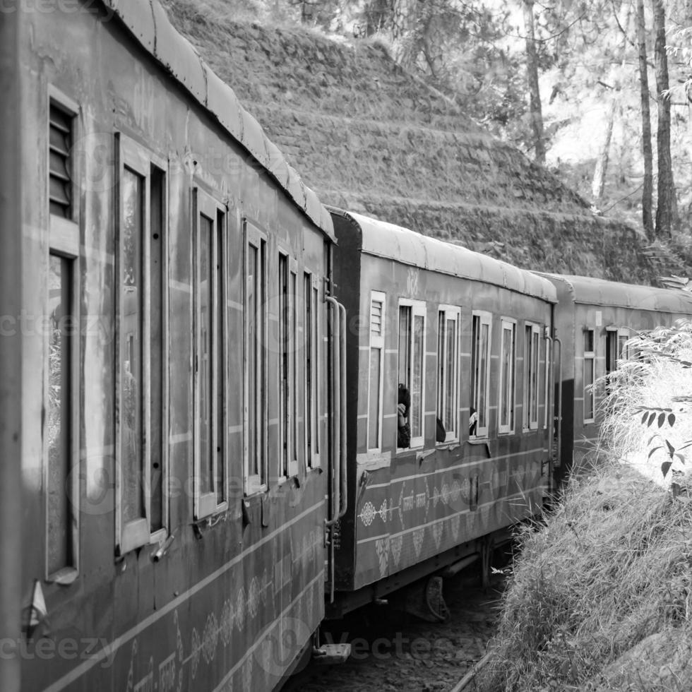 speelgoed- trein in beweging Aan berg helling, mooi visie, 1 kant berg, 1 kant vallei in beweging Aan spoorweg naar de heuvel, tussen groen natuurlijk Woud. speelgoed- trein van kalka naar shimla in india-zwart en wit foto