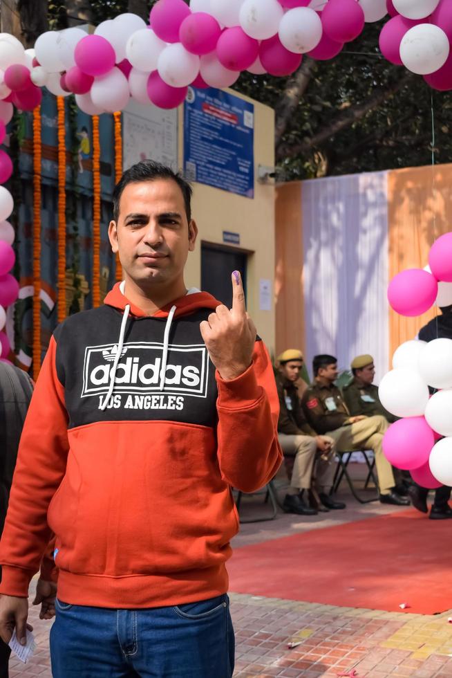 nieuw Delhi, Indië - december 04 2022 - niet geïdentificeerd mensen tonen hun met inkt gemarkeerd vingers na gieten stemmen in voorkant van peiling stand van oosten- Delhi Oppervlakte voor mcd lokaal lichaam verkiezingen 2022 foto