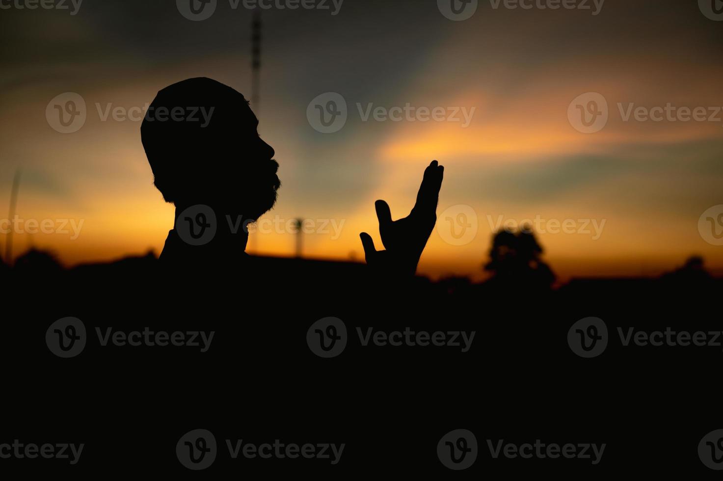 silhouet jong Aziatisch moslim Mens bidden Aan zonsondergang, ramadan festival concept foto