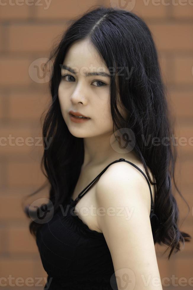 portret van hipster meisje op bakstenen muur achtergrond, mooie aziatische vrouw poseert om een foto te maken, kawaii-stijl