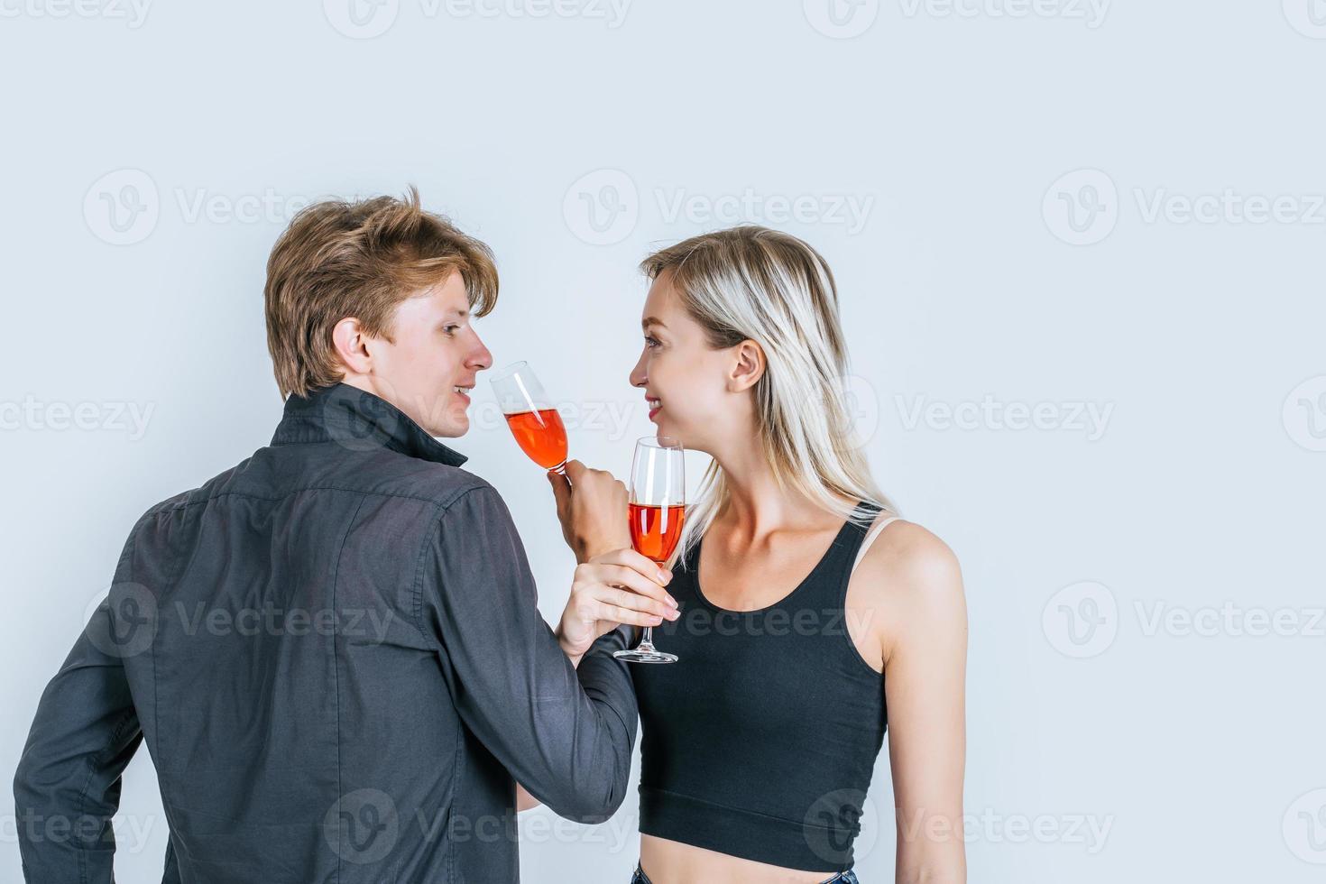 portret van gelukkige jonge paar wijn drinken in de studio foto