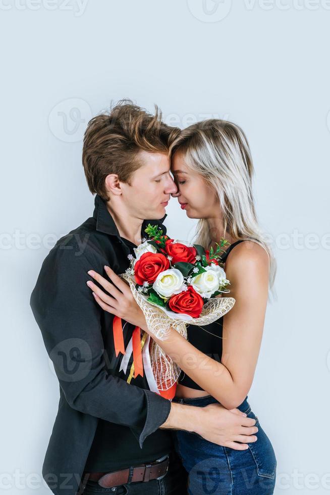 portret van gelukkig jong koppel met bloemen in studio foto