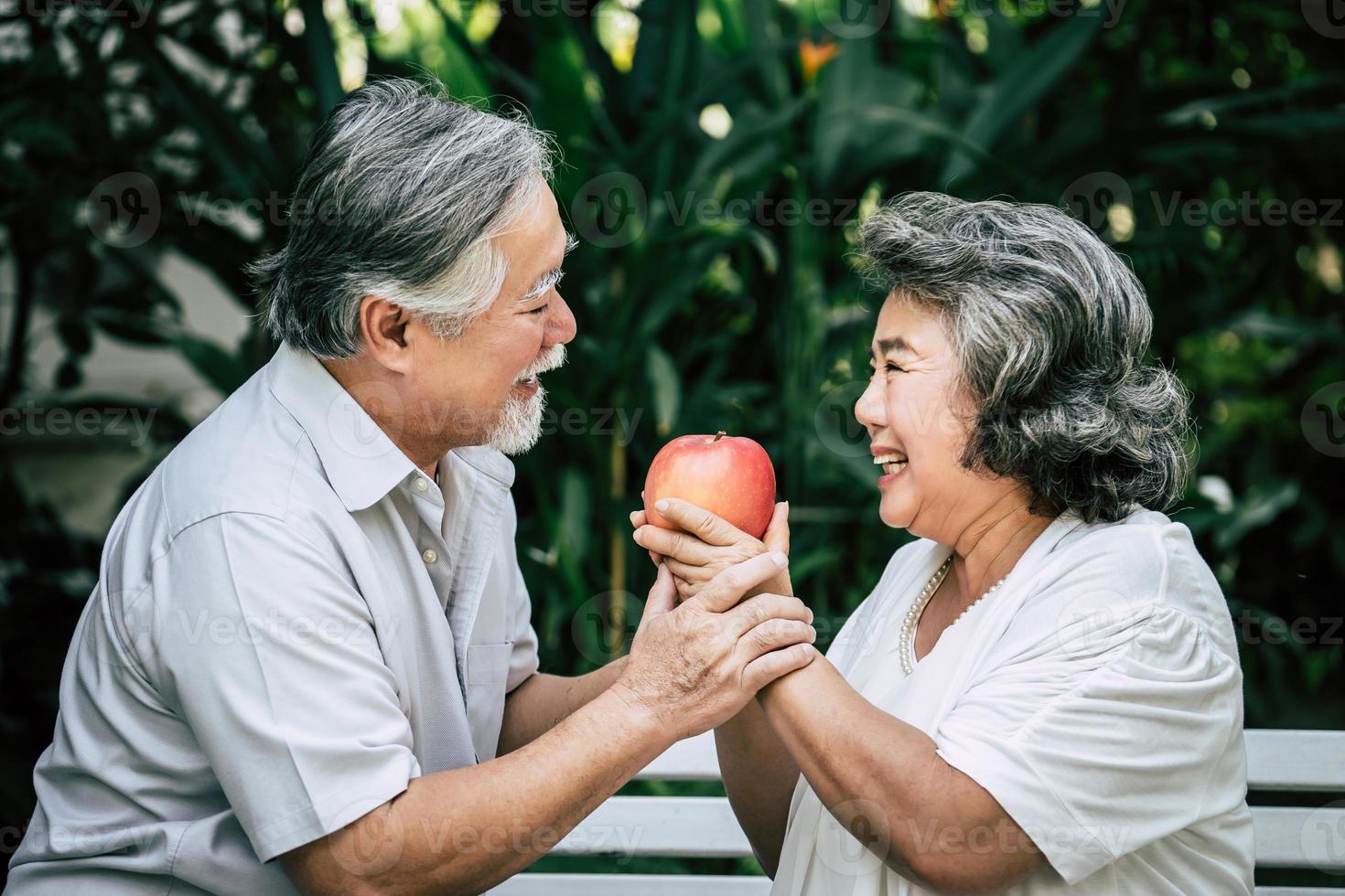 bejaarde echtpaar spelen en eten wat fruit foto