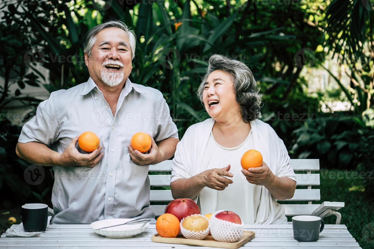 bejaarde echtpaar spelen en eten wat fruit foto