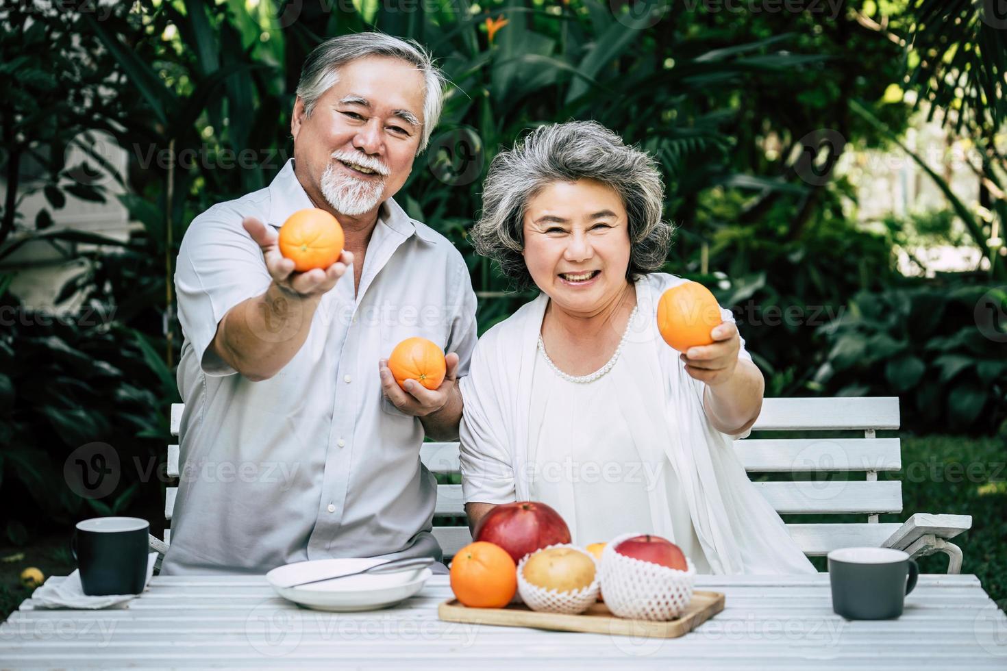 bejaarde echtpaar spelen en eten wat fruit foto