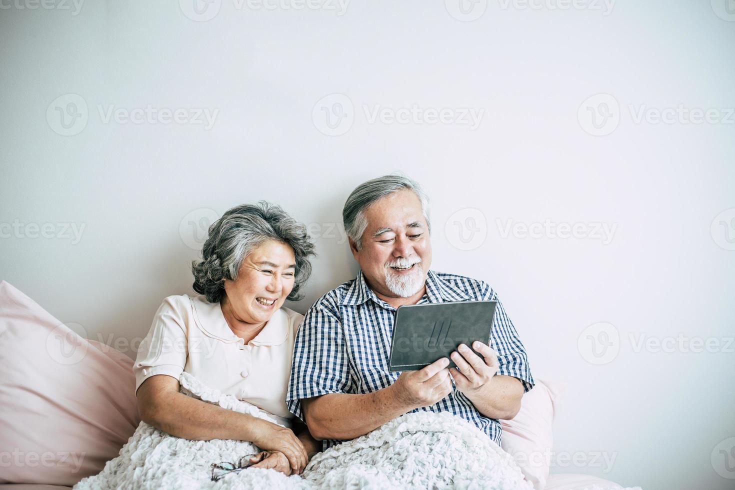 bejaarde echtpaar met behulp van een tabletcomputer foto