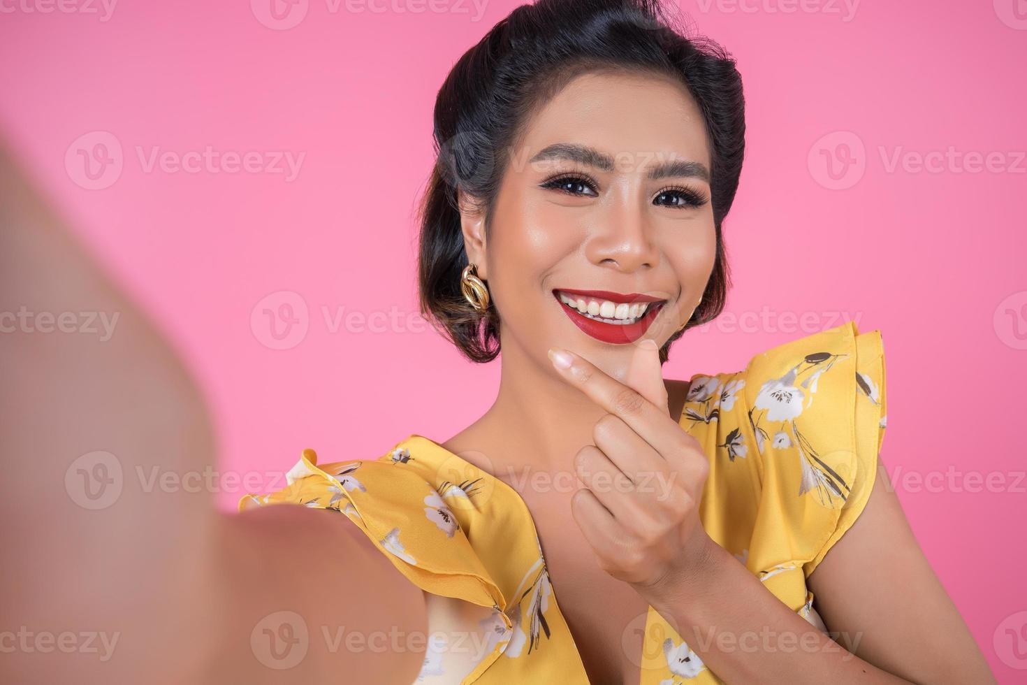 mooie modieuze vrouw die een selfie met haar telefoon neemt foto