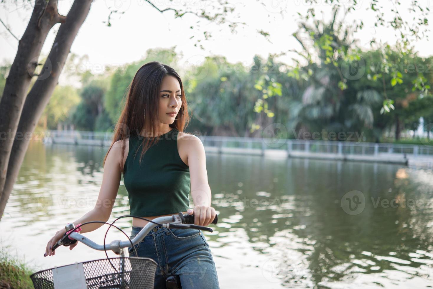 mooie jonge vrouw fietsten in groen park foto
