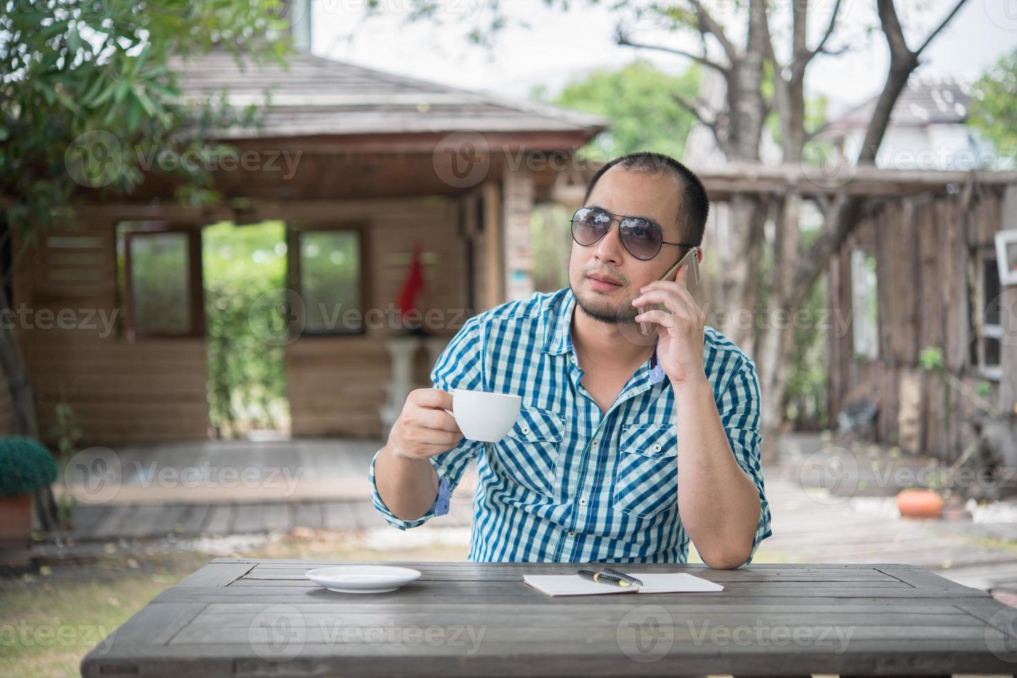 jonge zakenman met behulp van smartphone tijdens het werken in de tuin foto