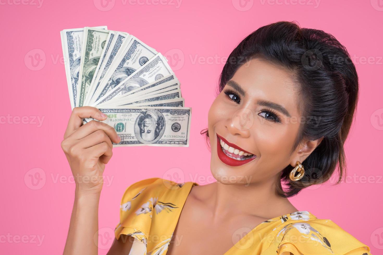 gelukkig modieuze vrouw met geld om te winkelen foto