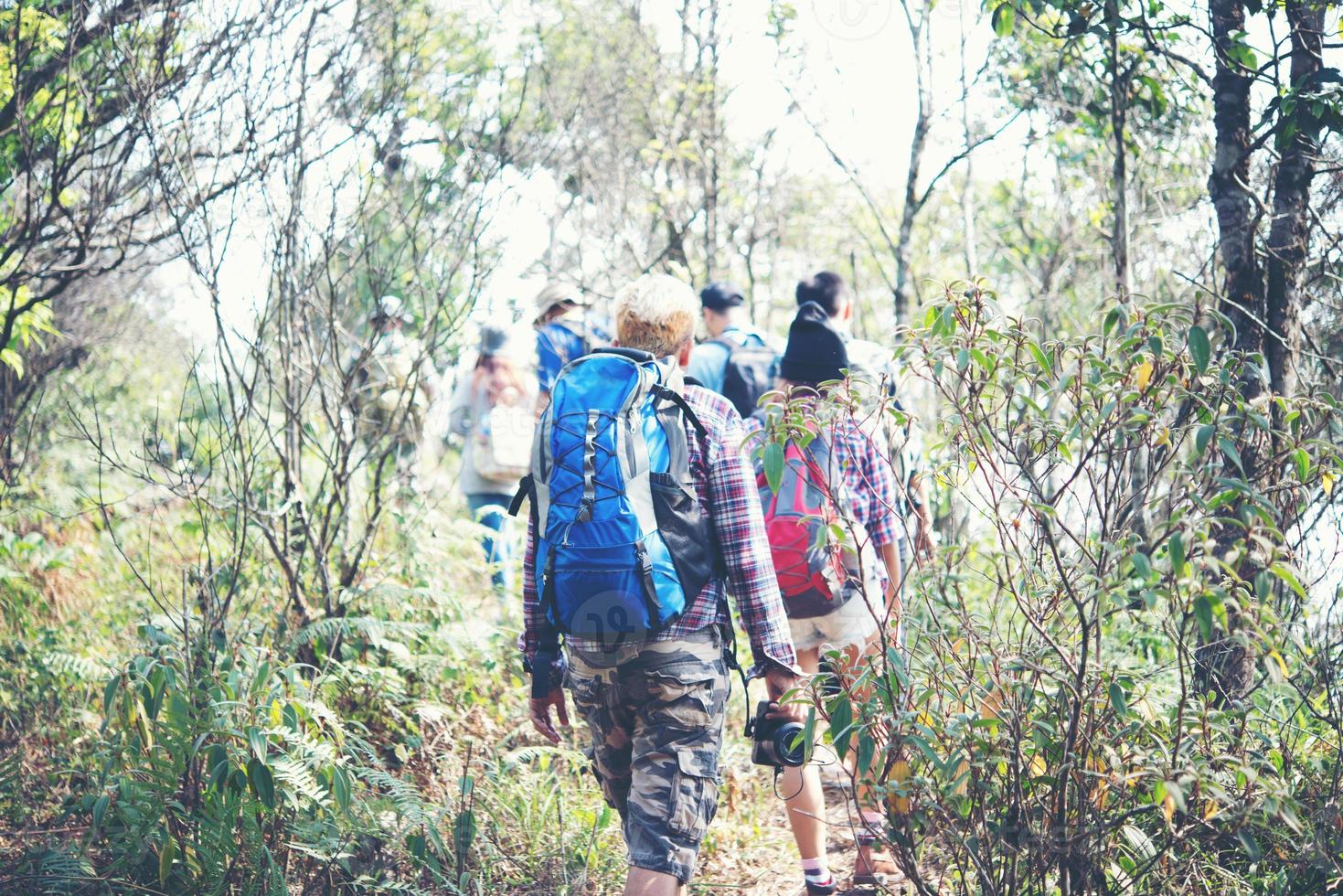 close-up van vrienden lopen met rugzakken in bos vanaf achterkant foto