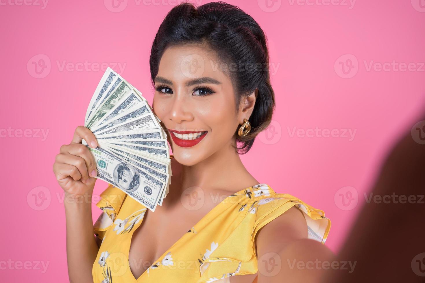 gelukkig modieuze vrouw met geld om te winkelen foto