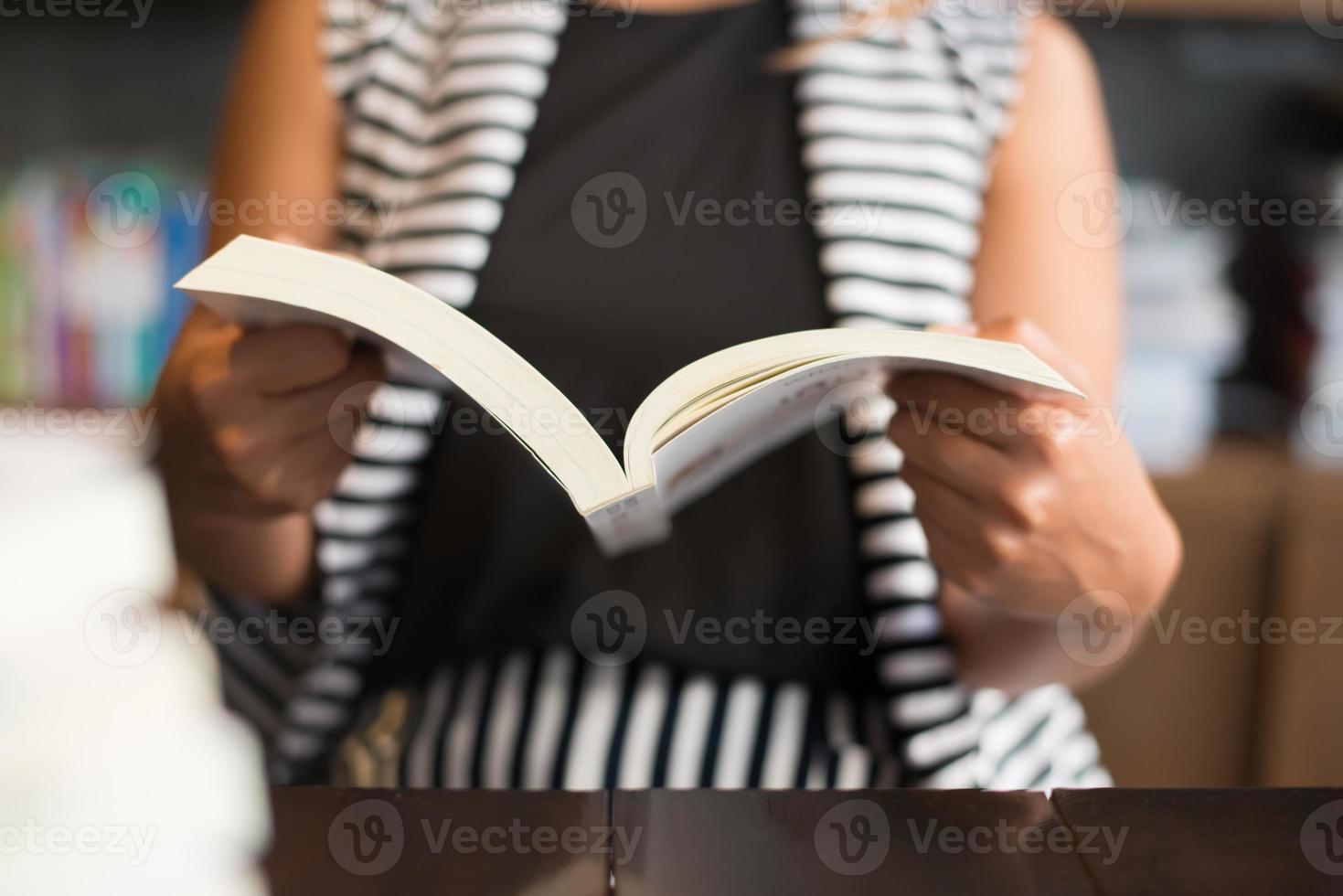 close-up van vrouw die een boek in bibliotheek leest foto