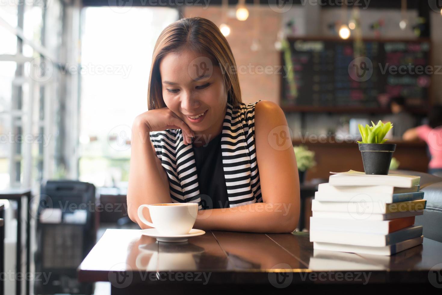 Aziatische vrouw ontspannen en lezen van een boek in het café foto