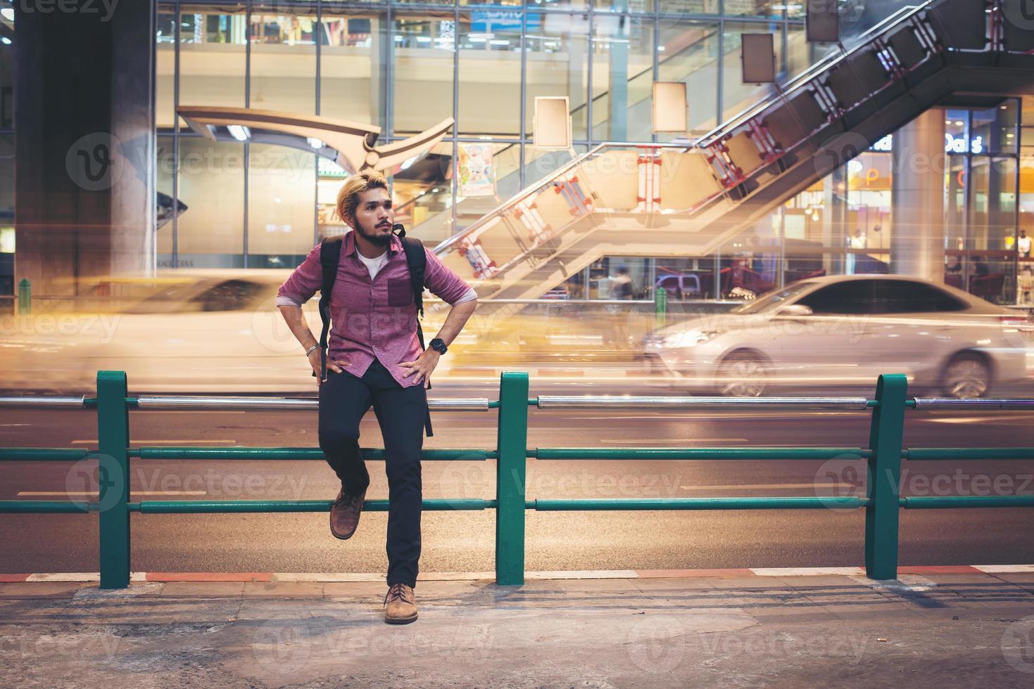 hipster bebaarde man zittend op reling met auto beweging achtergrond foto