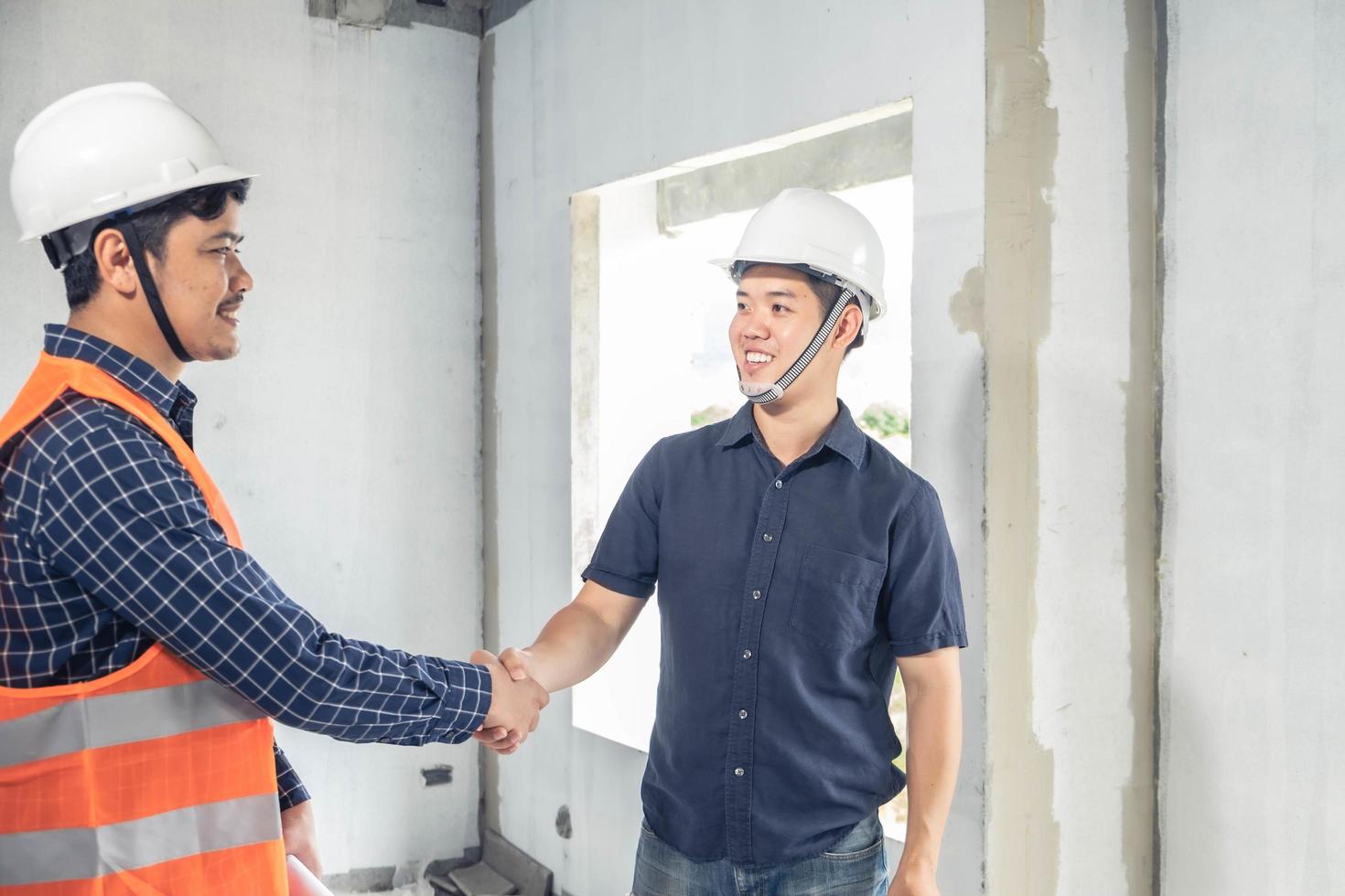 twee jonge ingenieurs die elkaar de hand schudden foto