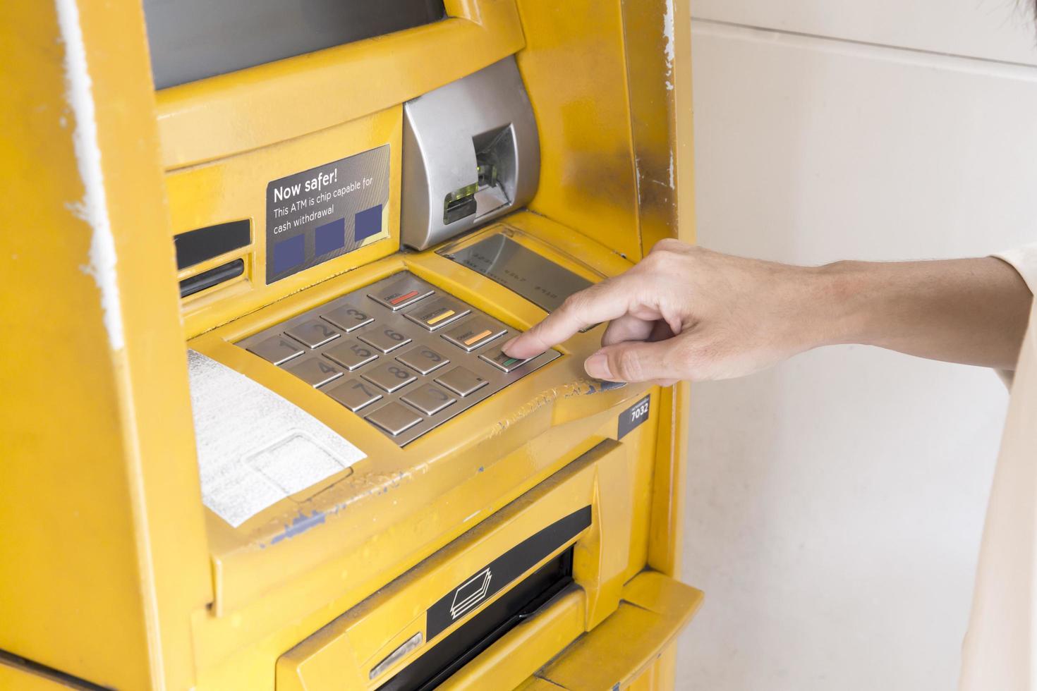 close up van een hand knoppen te drukken op een ATM-machine foto