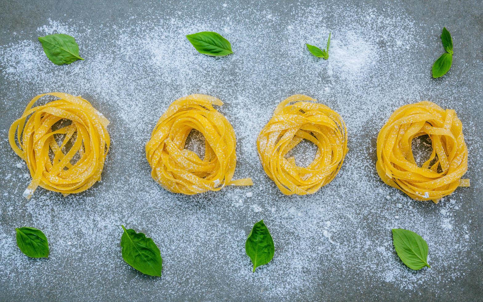 verse pasta en basilicum op een grijze achtergrond foto