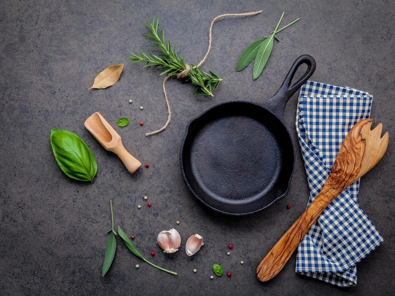 koekenpan met kruiden en een houten gebruiksvoorwerp foto