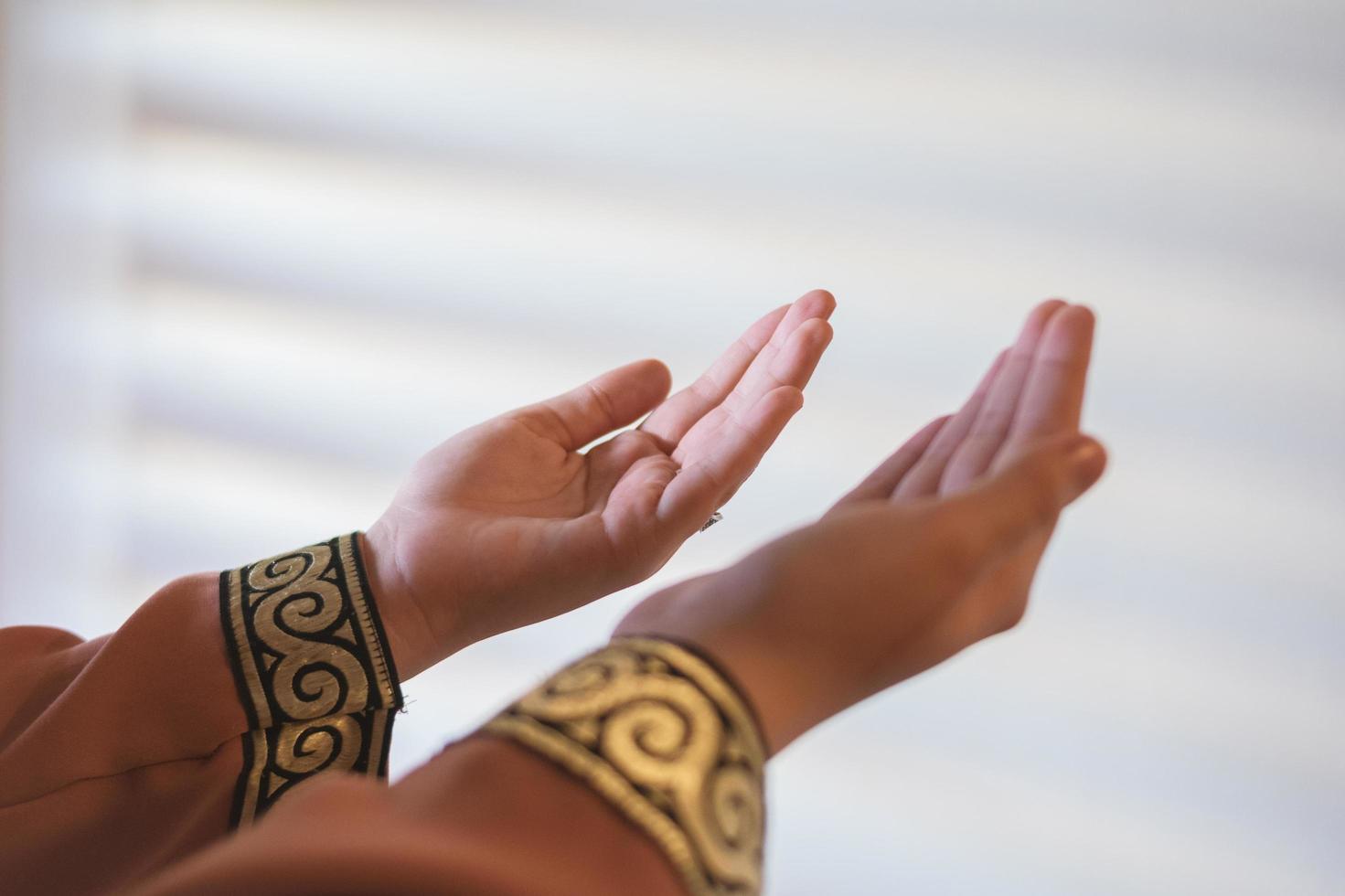 handen van een moslim of islamitische vrouw gebaren tijdens het bidden thuis foto