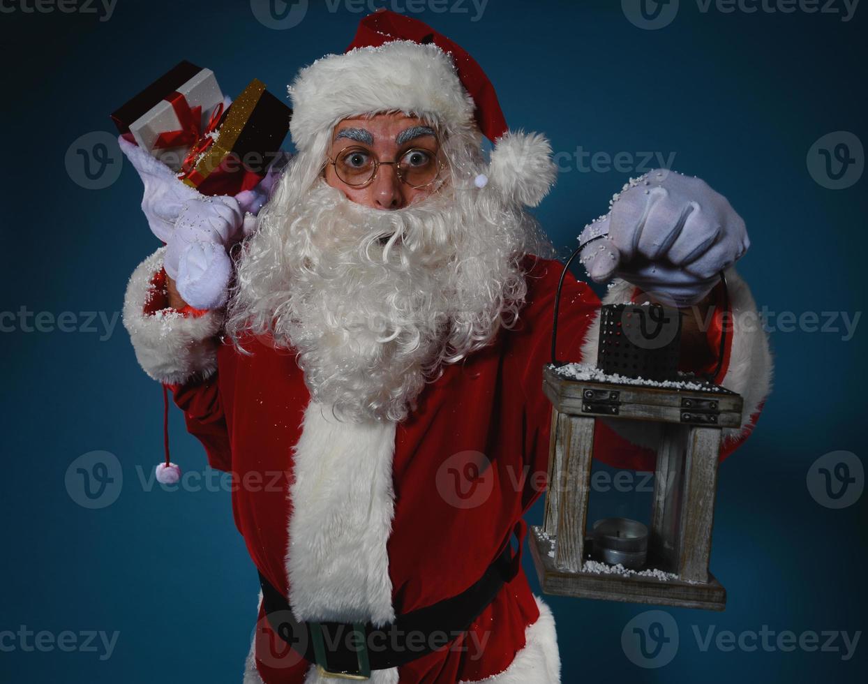 verrast de kerstman claus met een zak vol van cadeaus foto