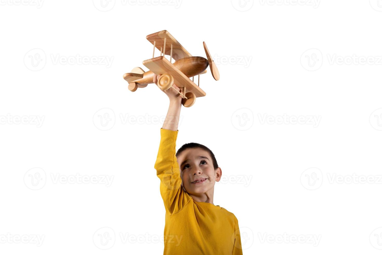 kind Toneelstukken met een houten speelgoed- vliegtuig. geïsoleerd Aan wit achtergrond foto