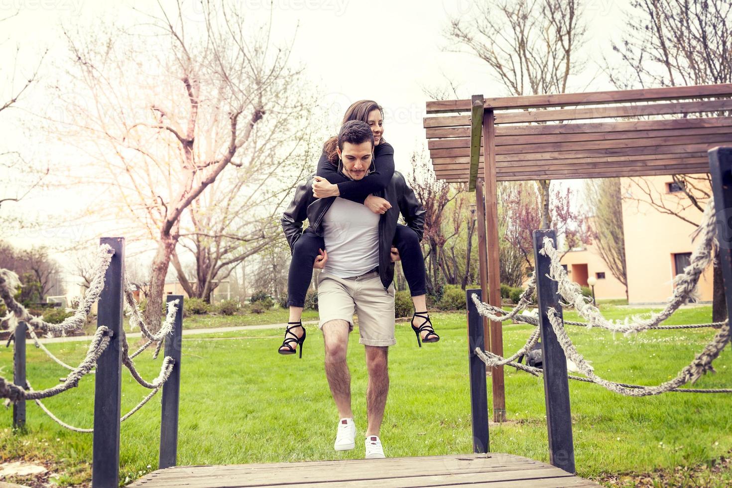 jong jongen hebben pret vervelend haar vriendin Aan zijn schouders foto