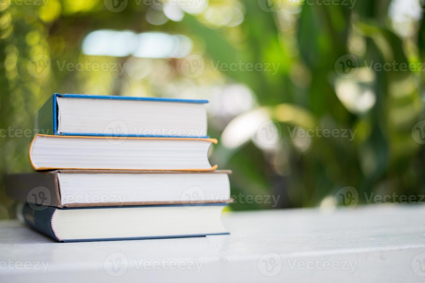 close-up stapel boeken, buiten geschoten onder duidelijke natuurlijke bokeh achtergrond foto