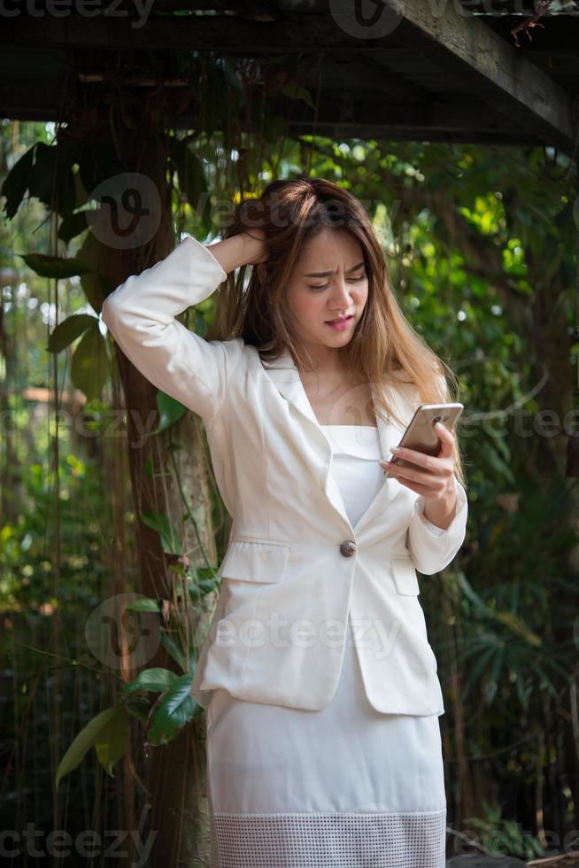 jonge zakenvrouw kijken naar telefoon gestrest voor het werk foto