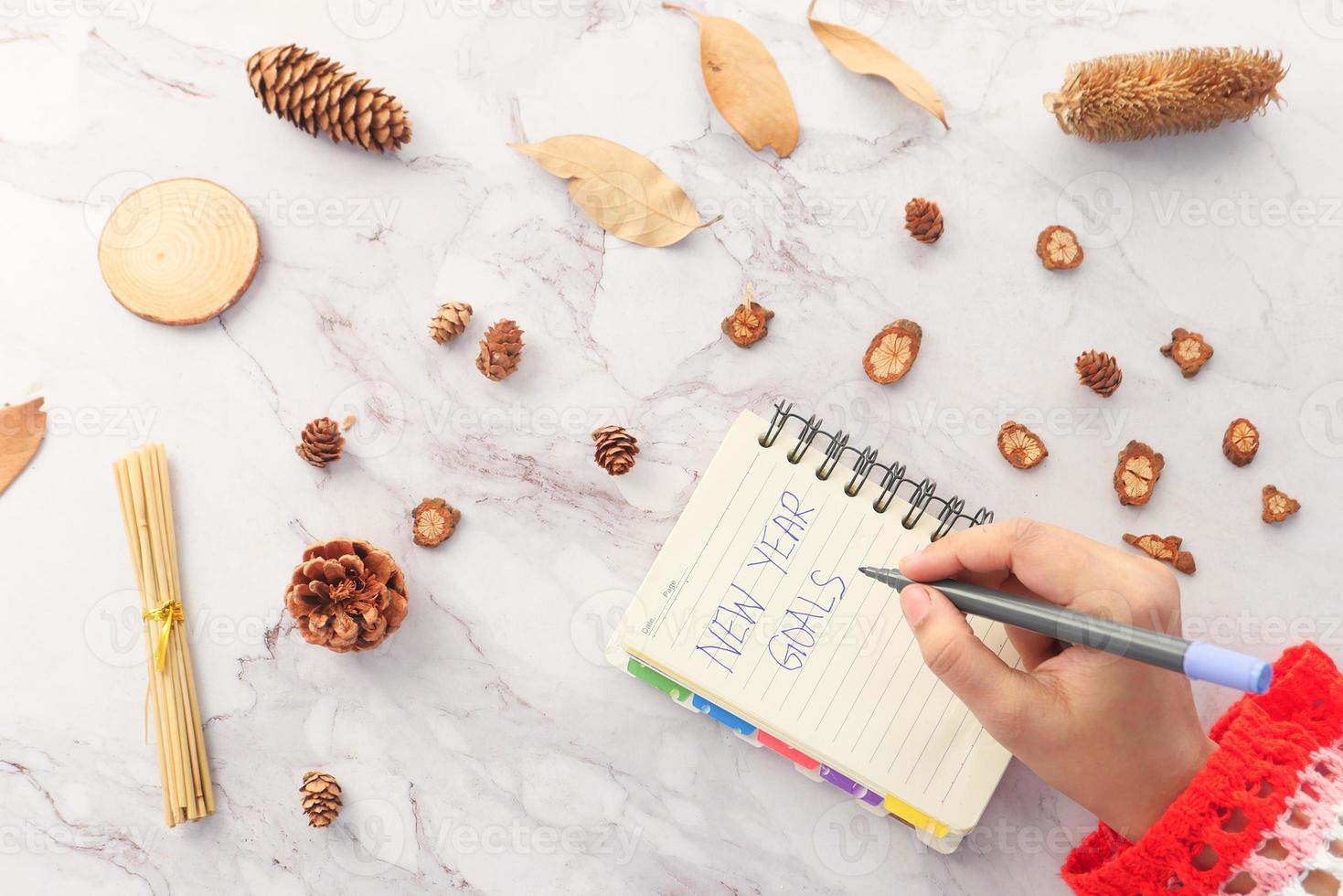 vrouw hand schrijven nieuwe jaardoelen op papier foto