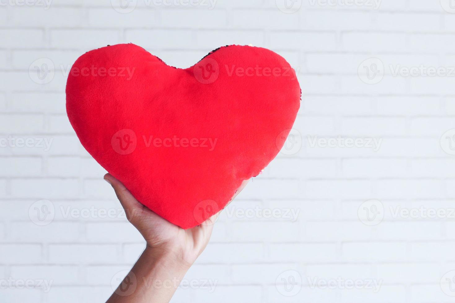 hand met rood hartsymbool op witte achtergrond foto
