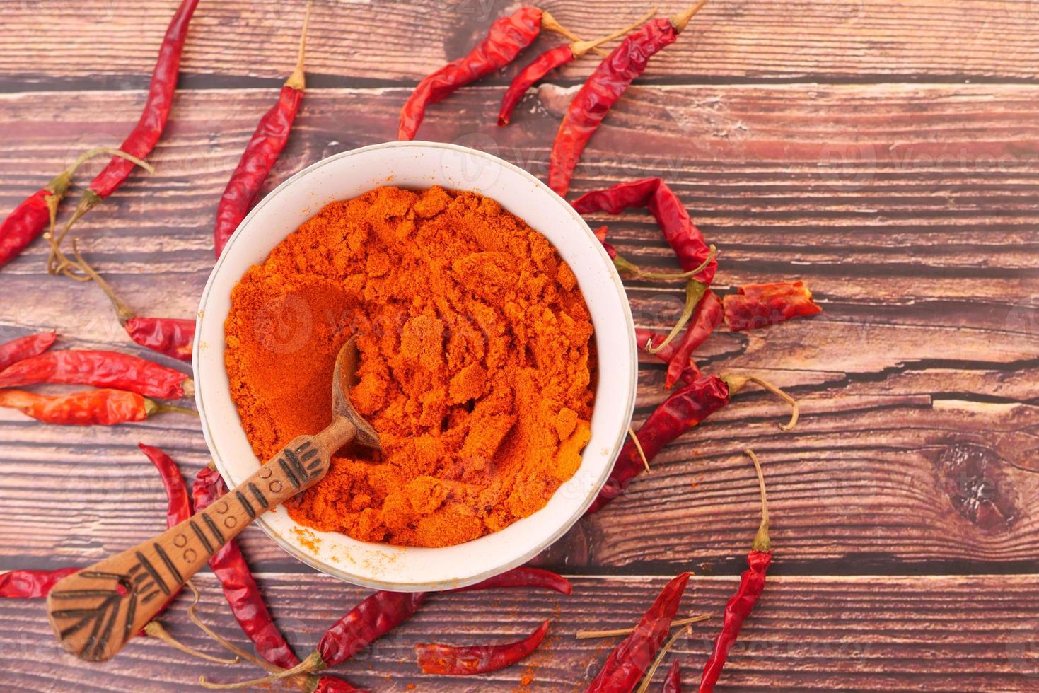 chilipoeder en gedroogde paprika's op tafel achtergrond foto