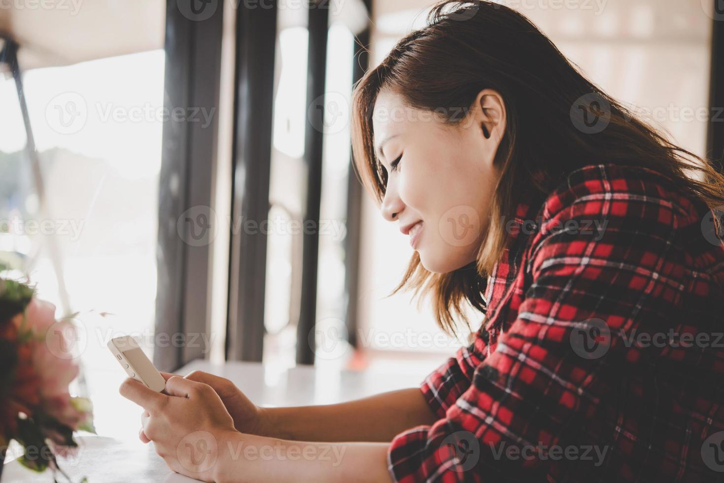 close-up van een vrouw die lacht terwijl mobiele telefoon en sms'en foto