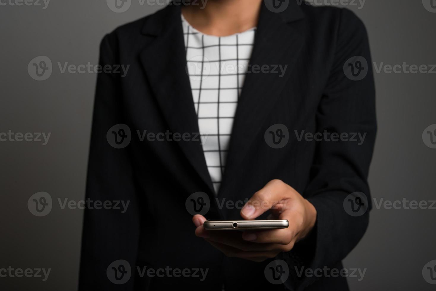 jonge zaken vrouw met behulp van mobiele telefoon geïsoleerd op zwarte achtergrond foto