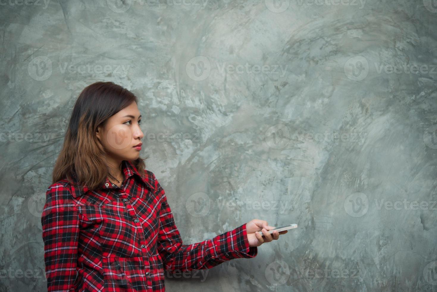 jonge hipster vrouw met smartphone geïsoleerd op grunge achtergrond foto