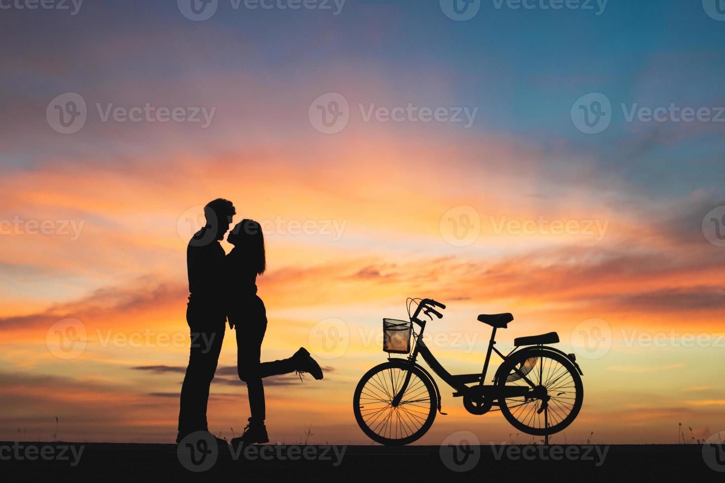 silhouet van paar verliefd kussen in zonsondergang foto