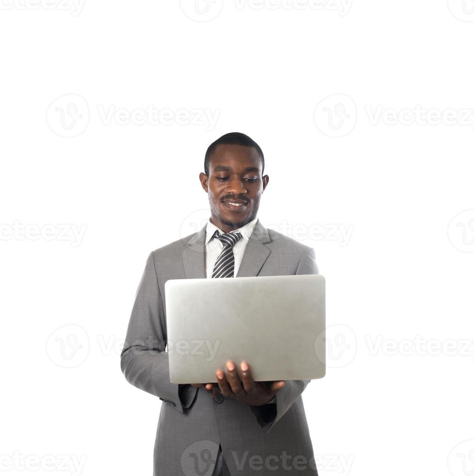 jonge zakenman die met laptop werkt die op witte achtergrond wordt geïsoleerd foto