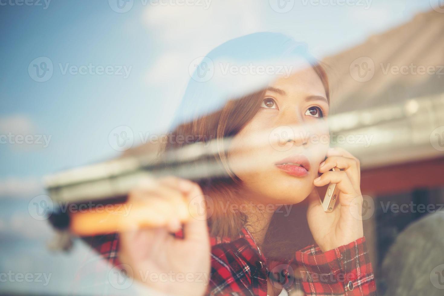 portret van een leuke vrouw die zich dichtbij venster in het koffie bevindt foto