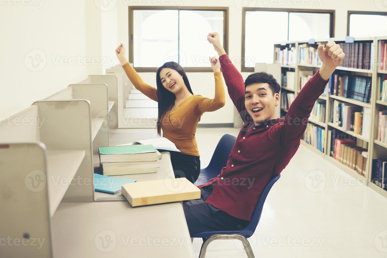 opgewonden gelukkige succesvolle studenten zegevieren met opgeheven handen foto