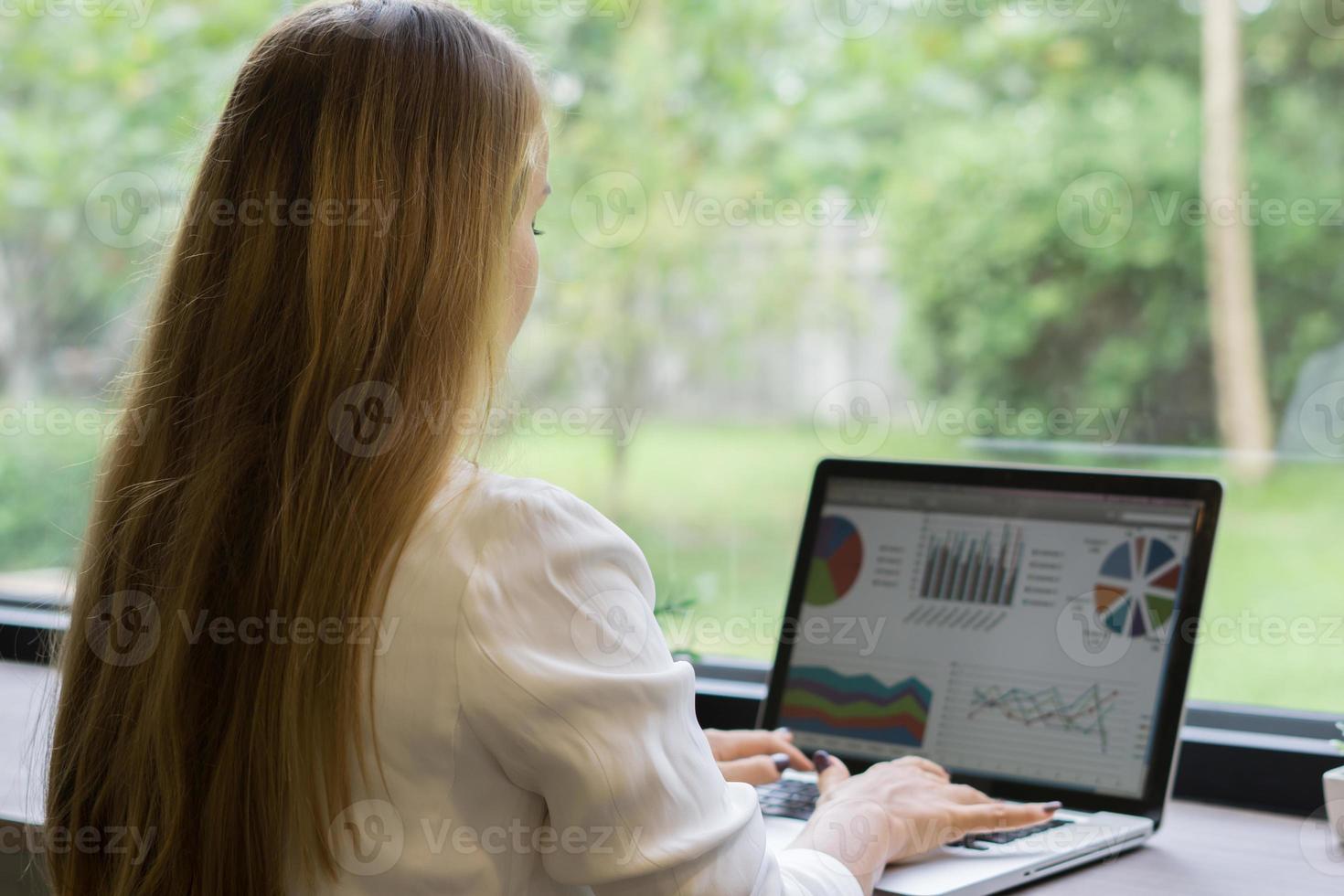 jonge zaken vrouw die op laptop op kantoor werkt foto