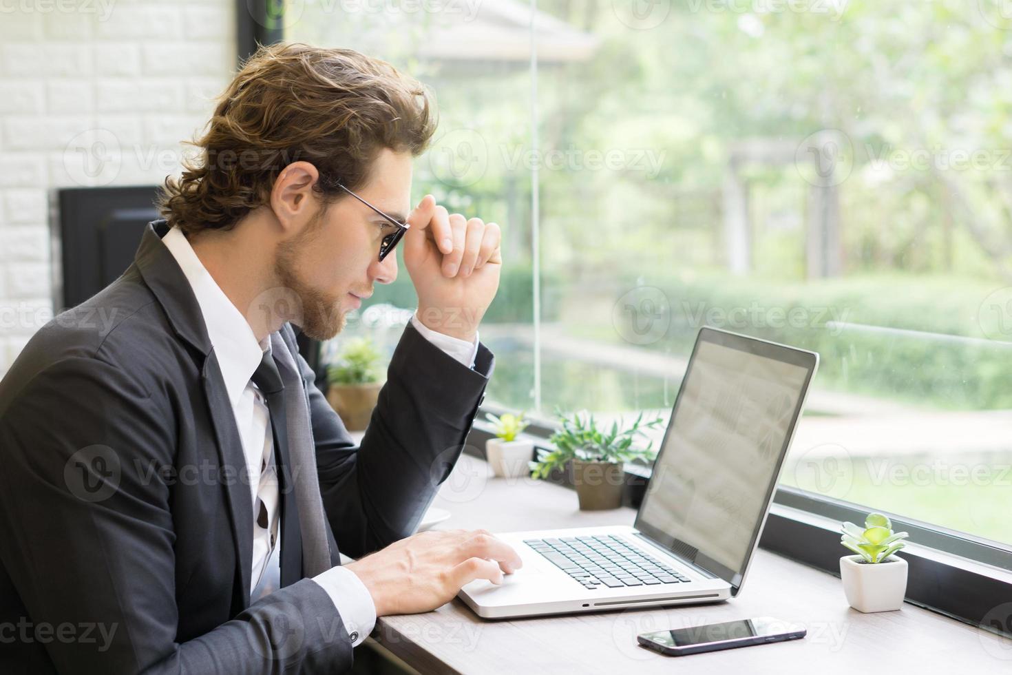 jonge zakenman die op laptop op kantoor werkt foto